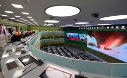 Russian President Vladimir Putin, fifth left, and other top officials oversee the test launch of the Avangard hypersonic missile from the Defense Ministry's control room in Moscow, Dec. 26, 2018.