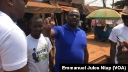 Armand Okol, candidat députe en bleu fait le porte à porte dans l’arrondissement de Yaoundé, le 1er février 2020. (VOA/Emmanuel Jules Ntap)