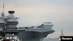 The Royal Navy's new aircraft carrier, HMS Queen Elizabeth, is towed by tugs as it arrives at Portsmouth Naval base, its new home port, in Portsmouth, Britain, Aug. 16, 2017.