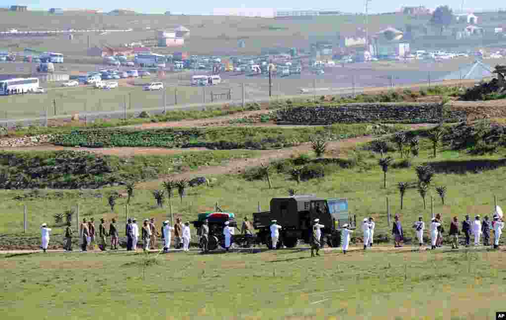 Peti mati mantan presiden Afrika Selatan Nelson Mandela dibawa di atas kereta senjata untuk penguburan tradisional setelah upacara pemakaman di Qunu, Afrika Selatan, 15 Desember 2013.