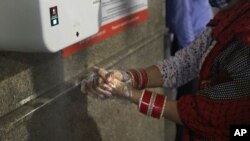 ស្ត្រី​ម្នាក់​លាង​សម្អាត​ដៃ​នៅ​ស្ថានីយ​រថភ្លើង មុន​ពេល​ជិះ​រថភ្លើង​នៅ​ក្នុង​ក្រុង Gurugram ប្រទេស​ឥណ្ឌា កាលពី​ថ្ងៃទី៧ ខែកញ្ញា ឆ្នាំ២០២០។