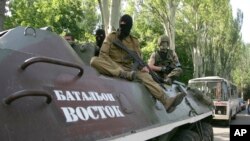 Kelompok bersenjata pro-Rusia duduk di atas kendaraan lapis baja bertuliskan "Battalion Vostok (Timur)" saat berpatroli di Donetsk, Ukraina, 20 Mei 2014 (Foto: dok).
