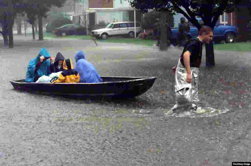 A Langley Air Force Base, Va., firefighter pulls a boat loaded with evacuees through the flood waters of Hurricane Floyd on Sept. 16, 1999. (Credit: U.S. Air Force.)