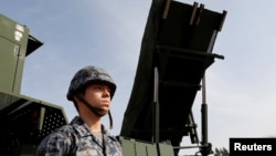 一名日本陆上自卫队成员站在PAC-3导弹拦截器前。（2018年1月18日）