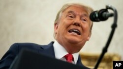 Donald Trump speaks during a ceremony to present the Presidential Medal of Freedom to former football coach Lou Holtz, in the Oval Office of the White House, Dec. 3, 2020, in Washington. 