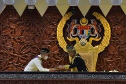 Sultan Abdullah Sultan Ahmad Shah, kanan, menerima dokumen dari Perdana Menteri Muhyiddin Yassin saat sidang parlemen di Kuala Lumpur, 18 Mei 2020. (Foto: AP)
