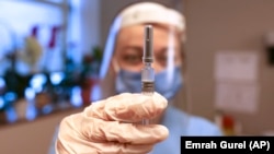Perawat Arzu Yildirim menunjukkan vaksin Covid-19 buatan Sinovac, CoronaVac, dalam uji klinis fase ketiga di Rumah Sakit Acibadem, Istanbul, Turki, 21 Desember 2020. (Foto: AP)