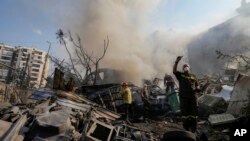 Petugas tanggap darurat memadamkan api yang menyala di lokasi serangan Israel ke Dahiyeh, Beirut, Lebanon, pada 1 November 2024. (Foto: AP/Hassan Ammar)