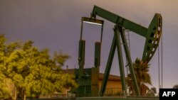 FILE - Pump jacks draw crude oil from the Long Beach Oil Field in Signal Hill, Calif., on March 9, 2020.