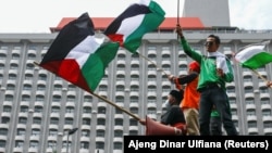 Sejumlah anggota organisasi buruh Indonesia memegang bendera Palestina saat melakukan aksi protes terhadap Israel di luar gedung PBB di Jakarta, 18 Mei 2021. (Foto: REUTERS/Ajeng Dinar Ulfiana)