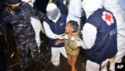 FILE - Medical workers help a Rohingya young girl upon arrival at Krueng Geukueh Port in North Aceh, Indonesia, Dec. 31, 2021.