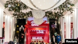 FILE - People wearing protective masks shop at Macy's Herald Square following the outbreak of the coronavirus disease (COVID-19) in the Manhattan borough of New York City, New York, Dec. 26, 2020.