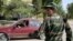 FILE - A serviceman stands guard at a roadblock outside Dushanbe, Sept. 24, 2010. 