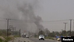 FILE - Smoke rises from a government building in al-Houta, the provincial capital of Yemen's southern Lahej province, March 21, 2015. 