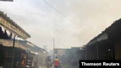 Smoke rises over the neighboring houses after the fire tore through an overcrowded New-Bell central prison in the port city of Douala, Cameroon, on May 28, 2020.