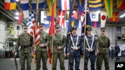 A flag party of U.S. Marines and Navy personnel take part in a ceremony marking the start of Talisman Saber 2017 aboard the USS Bonhomme Richard ship on the the Pacific Ocean off the coast of Sydney, June 29, 2017. (Jason Reed/Pool Photo via AP)