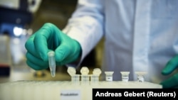 FILE - Employee Philipp Hoffmann, of German biopharmaceutical company CureVac, demonstrates research workflow on a vaccine for the coronavirus disease at a laboratory in Tuebingen, Germany, March 12, 2020. (REUTERS/Andreas Gebert/File Photo)