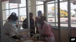 Perawat dari Kementerian Kesehatan Uganda memeriksa para penumpang yang tiba dari Republik Demokratik Kongo, Afrika Barat, di Kampala.