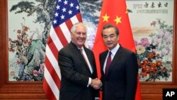 Sekretaris Negara AS Rex Tillerson (kiri), berjabat tangan dengan Menteri Luar Negeri China Wang Yi sebelum pertemuan mereka di Aula Besar Rakyat di Beijing, 30 September 2017.