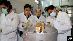 Des inspecteurs de l'Agence internationale de l'énergie atomique et des techniciens iraniens procèdent à des analyses au site de Natanz, à 322 kilomètres de Téhéran, Iran, 20 janvier 2014.