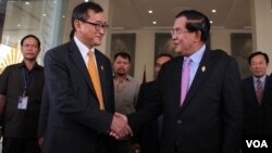 រូបឯកសារ៖ លោក​នាយក​រដ្ឋ​មន្រ្តី​ហ៊ុន​ សែន​ និង​លោក​សម​ រង្សី​ ប្រធាន​គណបក្ស​សង្គ្រោះ​ជាតិ​ ចាប់​ដៃ​គ្នា​នៅ​មុខ​​រដ្ឋសភាជាតិ​ បន្ទាប់​ពី​ការ​បោះឆ្នោត​ផ្តល់​សេចក្តី​ទុក​ចិត្ត​គណៈកម្មាធិការ​ជាតិ​រៀបចំ​ការបោះឆ្នោត ​ភ្នំពេញ​ ថ្ងៃ​ទី​៩​ ខែ​មេសា​ ឆ្នាំ​២០១៥។​​ (នូវ​ ពៅ​លក្ខិណា/VOA)