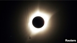 This file photo shows a partial solar eclipse happening as jet plane flies by the eclipse in Guernsey, Wyoming U.S., August 21, 2017. (REUTERS/Rick Wilking)