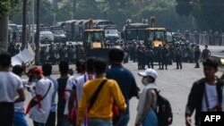 កងកម្លាំងប៉ូលិសជាច្រើននាក់កំពុងតទល់នឹងការប្រមូលផ្តុំរបស់អ្នកធ្វើបាតុកម្មប្រឆាំងនឹងរដ្ឋប្រហារយោធា នៅទីក្រុងរ៉ង់ហ្គូន ប្រទេសមីយ៉ាន់ម៉ា កាលពីថ្ងៃទី២២ ខែកុម្ភៈ ឆ្នាំ២០២២។ 