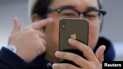 An attendee uses a new iPhone X during a presentation for the media in Beijing, China, Oct. 31, 2017.