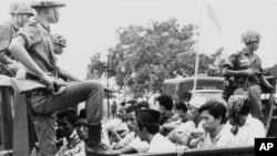 Anggota divisi pemuda Partai Komunis Indonesia (PKI) dijaga oleh tentara saat dibawa dengan truk ke penjara di Jakarta, 30 Oktober 1965. (Foto: Dok)