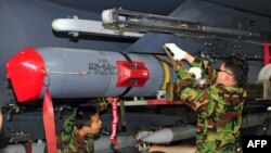 한국 공군 지상요원들이 F-15K 전투기에 미국산 AGM-84H 슬램이알(SLAM-ER) 공대지 정밀유도 미사일을 장착하고 있다.