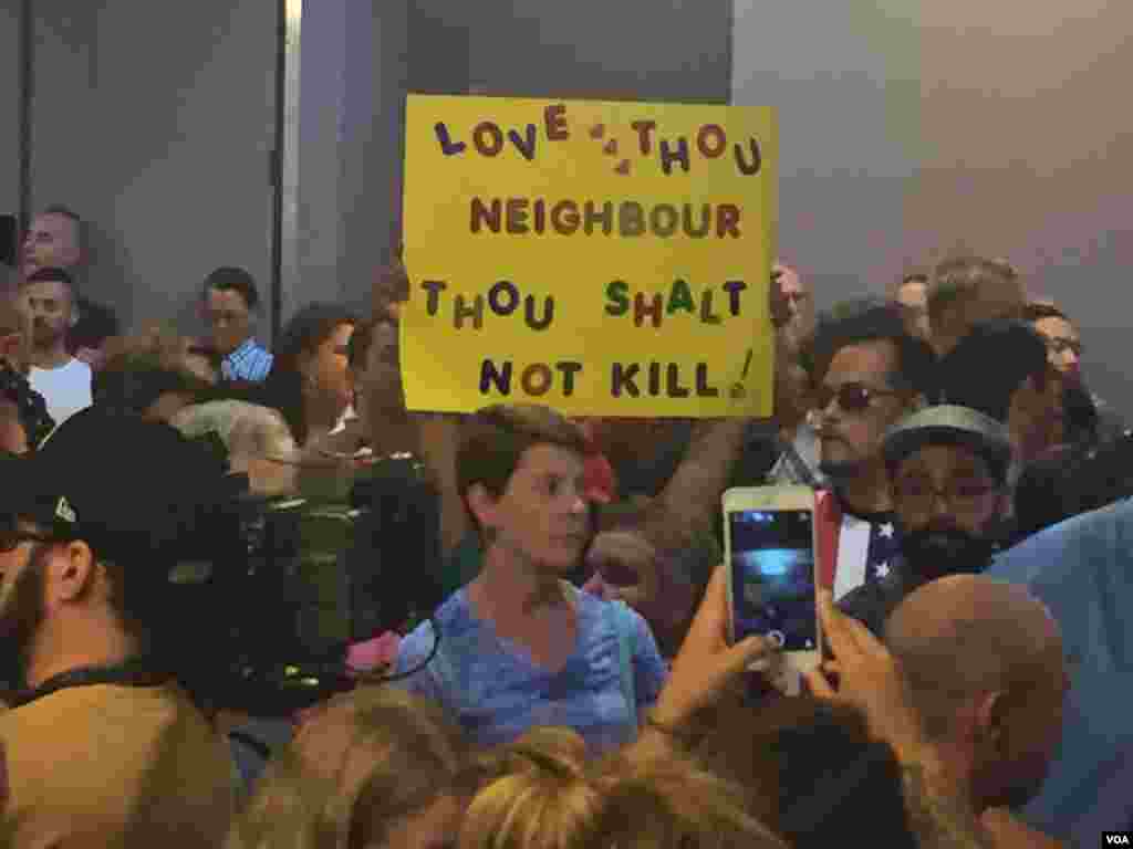 Mourners hold signs at a vigil at the LGBTQ Center of Southern Nevada (Las Vegas) in response to the shooting in Orlando. (K. Farabaugh/VOA)