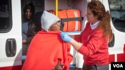 스페인 적십자사 요원들이 17일 발렌시아 항에 도착한 이주민을 돌보고 있다.