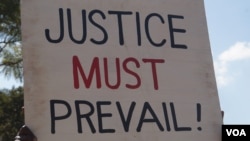 A protester holds a placard during post-election demonstration in the capital Lilongwe, Malawi, pushing for the resignation of the elctoral commision leader Jane Ansah.