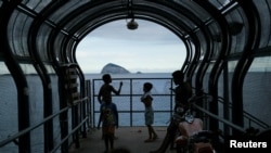 A child flies a kite atop a pedestrian bridge over Niemeyer Avenue in the Vidigal slum during the COVID-19 outbreak in Rio de Janeiro, Brazil, April 1, 2020. 