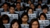 Staff members of the Mingpao newspaper hold their newspaper, with the headline on the former editor Kevin Lau, who was assaulted and injured, during a protest outside the Mingpao office in Hong Kong, Feb. 27, 2014. 