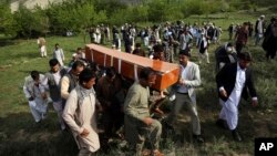 FILE - In this April 30, 2018 file photo, relatives, colleagues and friends of AFP chief photographer, Shah Marai, who was killed that day in a second suicide attack, carry his coffin in his village, Guldara, a district of Kabul province, Afghanistan. (AP
