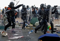 FILE - A policeman fires a pepper ball gun toward protesters near the Legislative Council in Hong Kong, June 12, 2019.