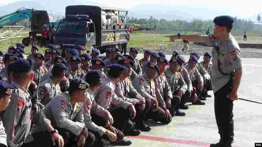 Police are given orders at the airport in Palu, Sulawesi, Indonesia, Oct. 3, 2018. Police sought to secure aid transfers to earthquake victims, but continuing shortages of food, water, fuel and medical supplies were causing many locals to leave affected areas. (Y. Litha/VOA)