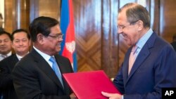 លោក Sergey Lavrov រដ្ឋមន្ត្រីការបរទេស​រុស្ស៊ី (ស្តាំ) និងលោក ស ខេង រដ្ឋមន្ត្រីការបរទេសកម្ពុជា ដោះដូរ​ឯកសារ​គ្នា​ក្នុង​អំឡុង​កិច្ចប្រជុំ​នៅ​ទីក្រុងមូស្គូ ប្រទេស​រុស្ស៊ី កាលពី​ថ្ងៃពុធ ទី២៧ ខែ​ឧសភា ឆ្នាំ២០១៥។ (រូបថត៖ AP/Pavel Golovkin)