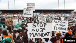 Supporters of Ivory Coast's Coast opposition coalition parties hold signs during a rally to protest against president Alassane Ouattara's bid for a third term in Abidjan, Ivory Coast, Oct. 10, 2020.