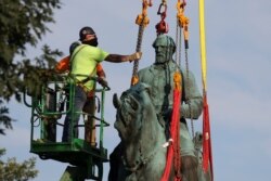 Workers remove a statue of Confederate General Robert E. Lee, after years of a legal battle over the contentious monument, in Charlottesville, Virginia, July 10, 2021. (REUTERS/Evelyn Hockstein)