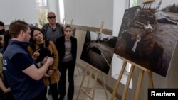 Nemačka ministarka spoljnih poslova Analena Berbok gleda fotografije ubijenih civila u jednoj crkvi u Buči (Foto: REUTERS/Carlos Barria)