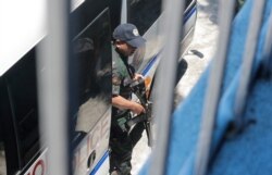 An armed police escort of opposition Senator Leila de Lima disembarks from their vehicle as she arrives to vote in the country's midterm elections Monday, May 13, 2019 in suburban Paranaque, southeast of Manila, Philippines.