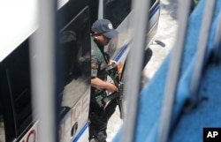 Seorang polisi bersenjata pengawalan Senator oposisi Leila de Lima turun dari kendaraan saat tiba untuk memberikan suara dalam pemilihan paruh waktu negara itu Senin, 13 Mei 2019 di Paranaque, tenggara Manila, Filipina. (Foto: AP)