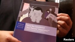 Boris Dittrich, advocacy director of the lesbian, gay bisexual, and transgender (LGBT) rights program at Human Rights Watch, poses with a report in Hong Kong, China, Nov. 15, 2017. 