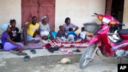 Genson Jean Baptiste, on phone, and his family gather outside their home after a 5.9 magnitude earthquake hit Haiti over the weekend, in Port-de-Paix, Haiti, Oct. 8, 2018.
