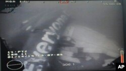 រូបភាព​ក្នុង​ទឹក​ដែល​មិន​បាន​កំណត់​ថ្ងៃ​ខែ​ថត​ដោយ​យាន​ Remotely Operated Vehicle (ROV) និង​ចេញ​ផ្សាយ​ដោយ​ក្រសួង​ការពារ​ជាតិ​សិង្ហបុរី។ រូបភាព​នេះ​បង្ហាញ​ពី​កម្ទេច​របស់​យន្តហោះ​ QZ8501 របស់​ក្រុមហ៊ុន​អាកាសចរណ៍ AirAsia ដែល​ស្ថិត​នៅ​ក្នុង​បាត​សមុទ្រ​ជា្វ។