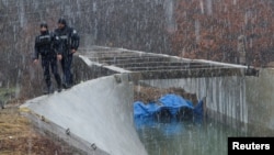 Police officers patrol near the damaged canal near Zubin Potok, Kosovo, Nov. 30, 2024.