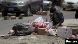 A boy searches for food amongst litter on a street in Sana'a, Yemen, April 8, 2015.