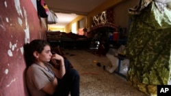 FILE - An internally displaced Yazidi who fled from an Iraqi town after advances by Islamic militants takes shelter at a school in Dahuk, 260 miles (420 kilometers) northwest of Baghdad.